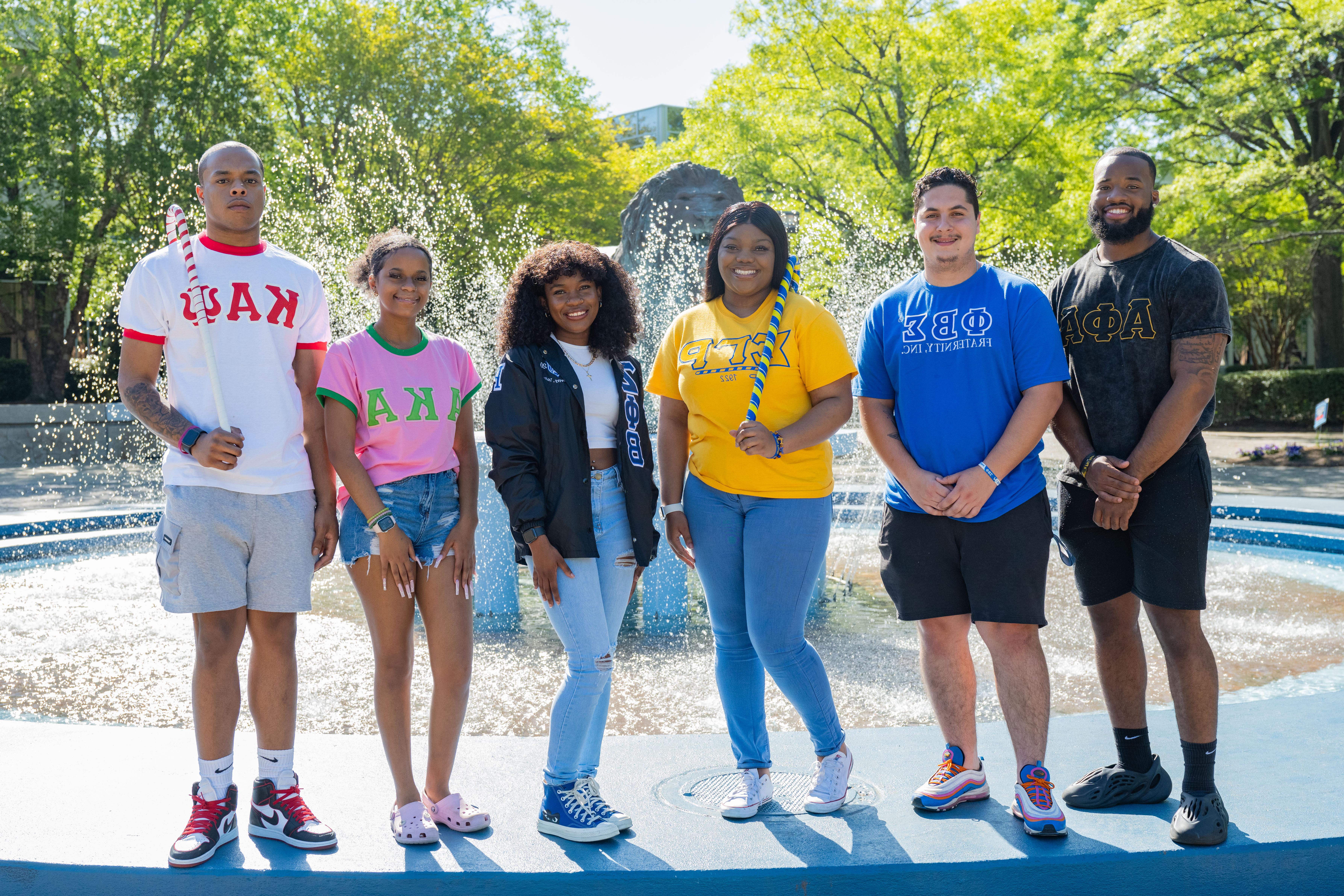 National Panhellenic fraternity and sorority members stand in front of fountain